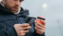 Mężczyzna z telefonem i kartą płatniczą